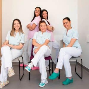 Equipo de la clínica Idexdental Miajadas posando en consulta con uniformes corporativos